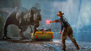 A scene from Jurassic Park showing a T-Rex confronting visitors, highlighting the Hollywood blockbuster that pioneered dubbed releases and helped expand Hollywood's reach in India.